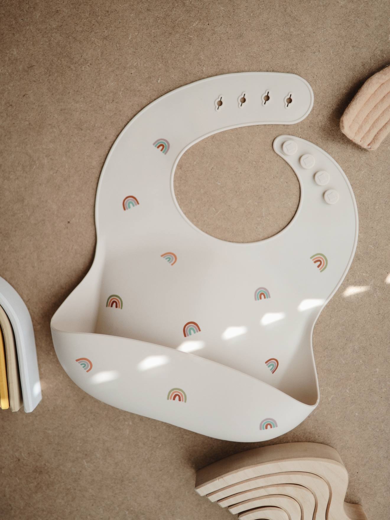 Bavoir avec récupérateur en silicone beige/arc en ciel (Mushie) - Image 1